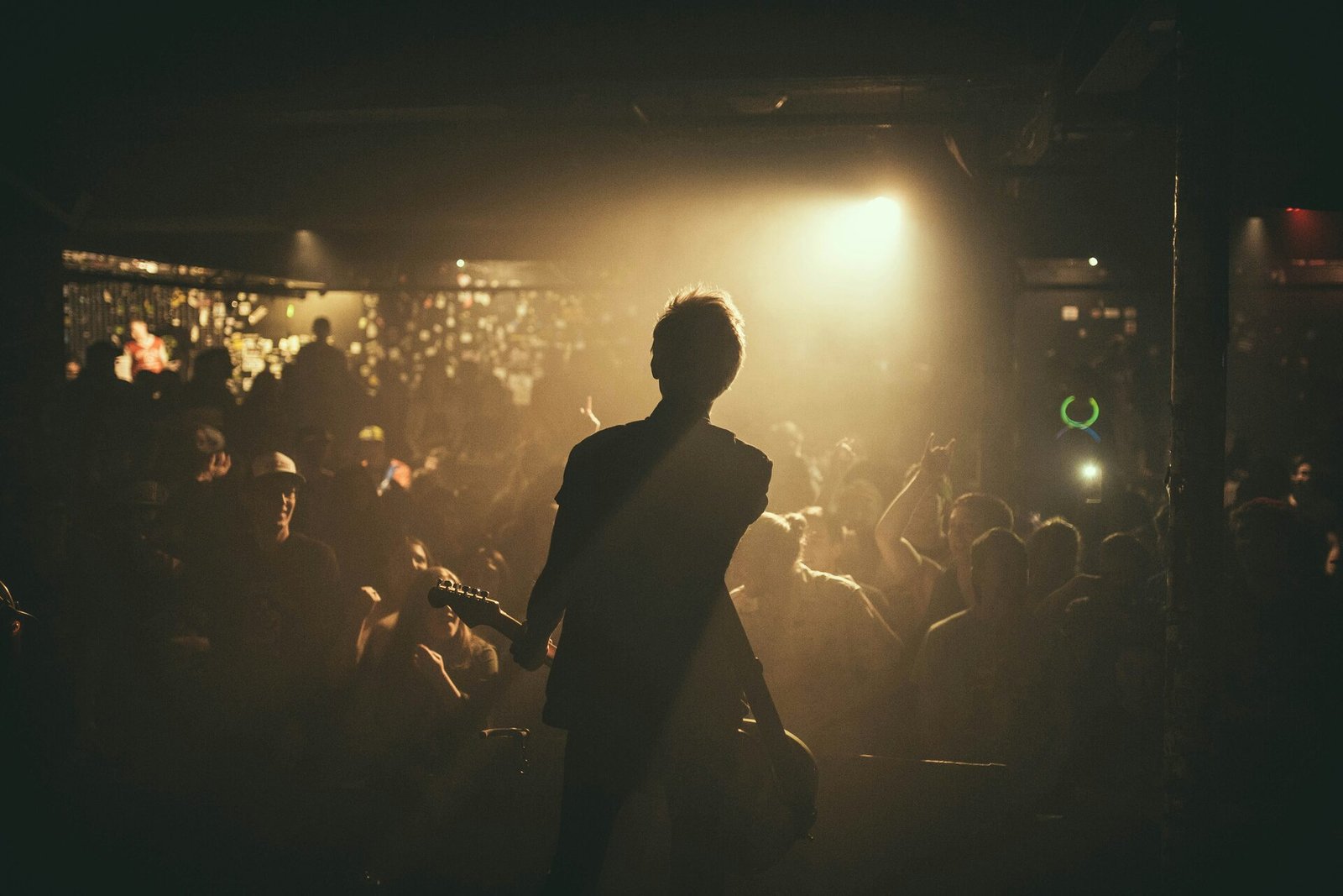 Concert crowd with hands raised under bright stage lights